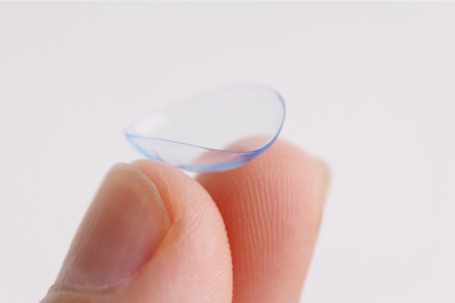 コンタクトレンズをつまんでいる